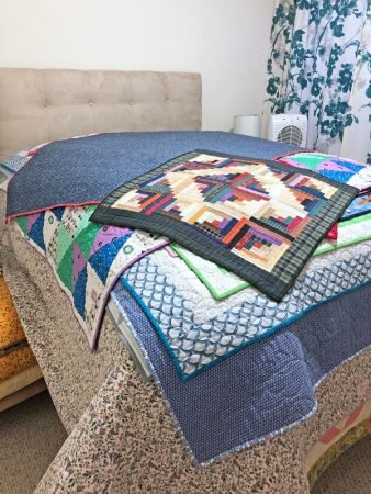bed with quilts piled on it!