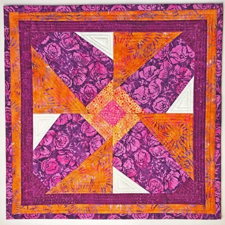 Top US quilting blog and shop, Kate Colleran Designs, shares about paper piecing quilts and her recent quilts. Quilt shown in bright orange and purple batiks