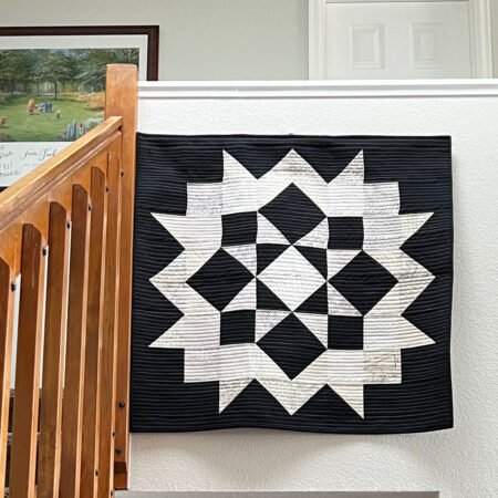 Top US quilting blog and shop, Kate Colleran Designs, shares about her remix of the Lady of the Lake quilt block! Image of a wall quilt hanging in black and whites.