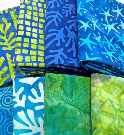 Top US quilting blog and shop, Kate Colleran Designs, shares about National Quilting Day and a surprise fabric giveaway! Image is a stack fo blue and green batiks
