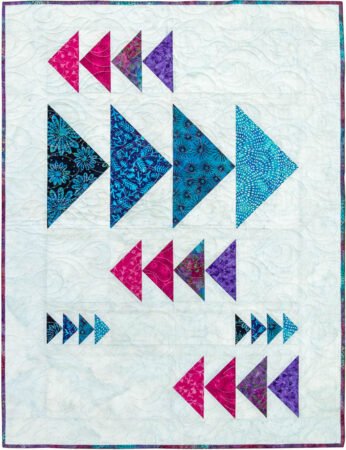 Top US quilting blog and shop, Kate Colleran Designs, shares Summer Twilight batiks and her project in the fabrics! Image is mini flying geese quilt in pink, blue and purple batiks