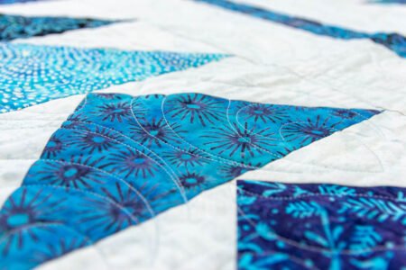Top US quilting blog and shop, Kate Colleran Designs, shares Summer Twilight batiks and her project in the fabrics! Image is a closeup of blue flying geese units