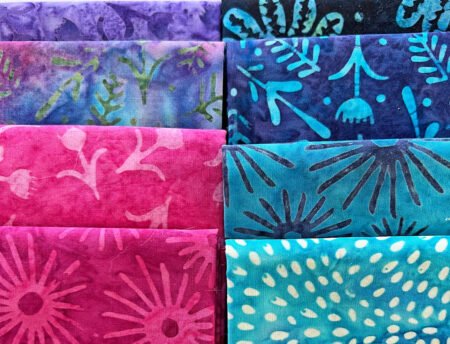 Top US quilting blog and shop, Kate Colleran Designs, shares Summer Twilight batiks and her project in the fabrics! Image is 8 batik fat quarters in pinks, blues and purples