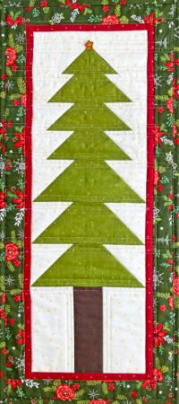 Festive Fir- a small pine tree quilt wall hanging in green, brown, white and red with a green poinsettias print border