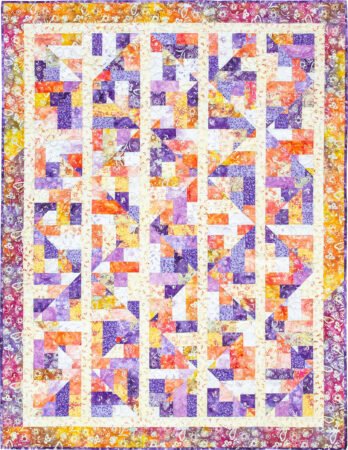 Top US quilting blog and shop, Kate Colleran Designs, shares about her new batik fabric line Winged Things and a FQ giveaway! Image is a pieced quilt in orange, purple, yellow and white batiks.