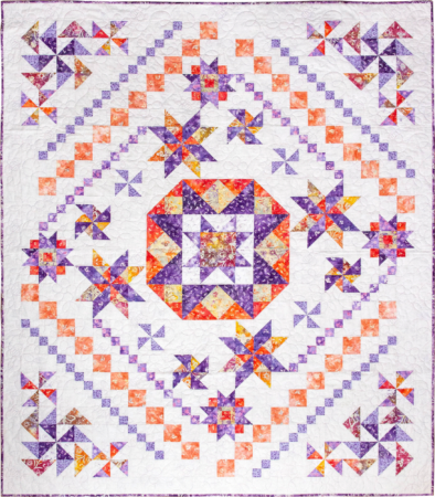 Top US quilting blog and shop, Kate Colleran Designs, shares about her new batik fabric line Winged Things and a FQ giveaway! Image is a block of the month star quilt with a white  background and purple, orange yellow and white batiks.