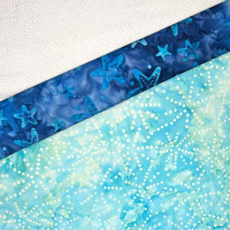 Top US quilting blog and shop, Kate Colleran Designs, shares a free quilt block pattern and shares about an upcoming QAL! Image is of 3 batik fabrics in blue and white.