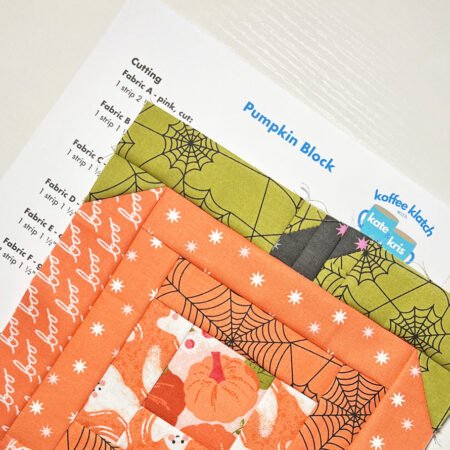 Top US quilting blog and shop, Kate Colleran Designs, shares about her new quilt along called Fall O'Ween! Image is a pumpkin quilt block in orange, green and black fabrics on top of a quilt pattern for the block.