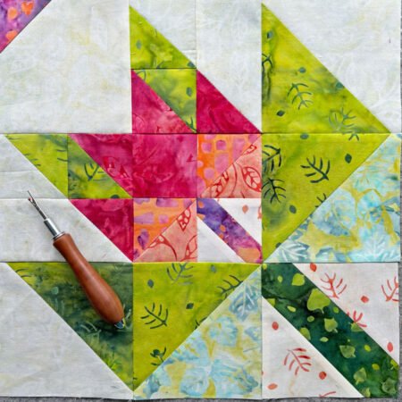 Top US quilting blog and shop, Kate Colleran Designs, shares about her September Block Remix challenge and her new block! Image is of a maple leaf in a maple leaf quilt block made in green, orange pink and purple batiks.