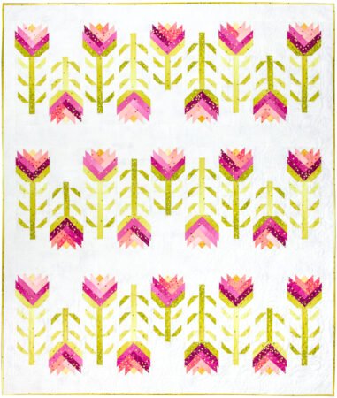 Top US quilting blog and shop, Kate Colleran Designs, shares about her book Patchwork Braids and using pieced strips in a braid. Image is a quilt made of pieced braid flowers in pink and green ombre fabric on white.