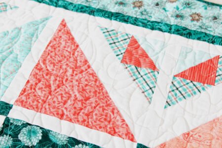 Top US quilting blog and shop, Kate Colleran Designs, shares about her new Chalk Hill Blue quilt pattern! Image is a close up of quilt showing orange, white and teal fabrics.