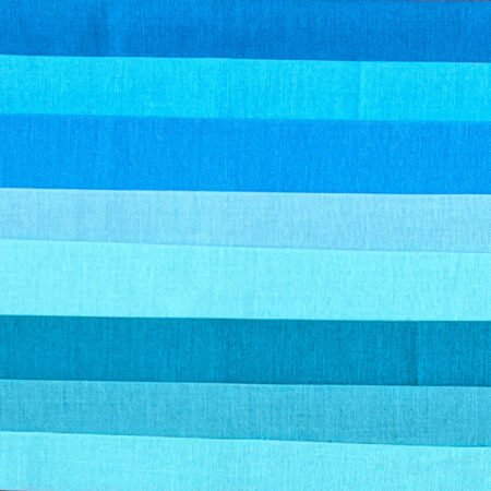 Top US quilting blog and shop, Kate Colleran Designs, shares about a quilt from Patchwork Braids and tips on recoloring a quilt. Image is a flat shot of a range of blue solid fabrics.