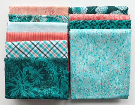 Top US quilting blog and shop, Kate Colleran Designs, shares about the Chalk Hill Blue fabric and a giveaway! Image shows 2 stacks of teal, orange, light blue and white fabrics.