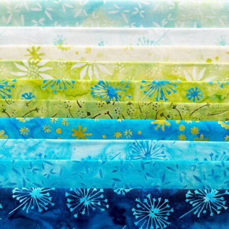 Top US quilting blog and shop, Kate Colleran Designs, shares about a quilt from Patchwork Braids and tips on recoloring a quilt. Image is a row of blue, green and white batiks.