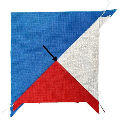 Top US quilting blog and shop, Kate Colleran Designs, shares about the Jingle Bell Pines Block Party Block 8 Tree Topper. Image is a blue, red and white partial square triangle unit before trimming.