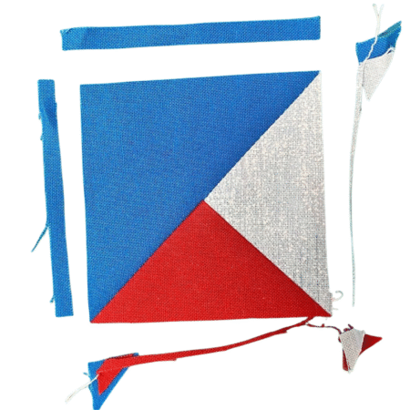 Top US quilting blog and shop, Kate Colleran Designs, shares about the Jingle Bell Pines Block Party Block 8 Tree Topper. Image is a blue, red and white partial quarter square triangle unit with trimmed edges showing.