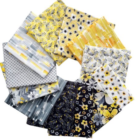 Top US quilting blog and shop, Kate Colleran Designs, shares about her quilt Gemstone and the quilt remake in Blissful Blooms. Images is a circle of fabric pieces in black, grey, yellow and white with flowers, leaves and abstract prints.