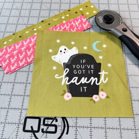 Top US quilting blog and shop, Kate Colleran Designs, shares about new projects using quilt blocks and how to resize. Image is a green halloween panel with a ghost and pink and green borders strips.