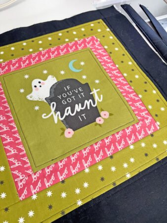 Top US quilting blog and shop, Kate Colleran Designs, shares about new projects using quilt blocks and how to resize. Image is of a green Halloween panel with pink, green and black borders.