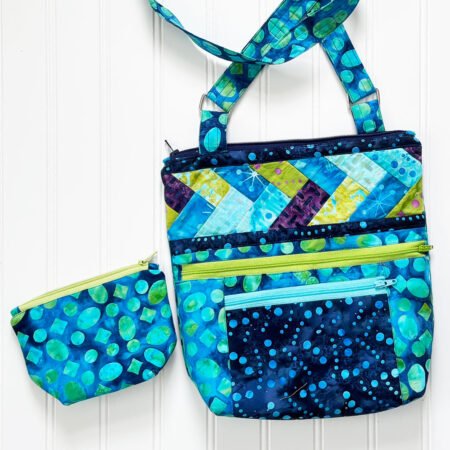 Top US quilting blog and shop, Kate Colleran Designs, shares about her new batik line called Garden Gate and a FQ bundle giveaway! Image is a cross body bag shown in batiks in blues, greens and a bit of magenta.