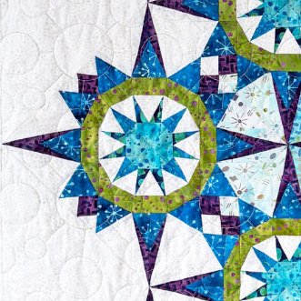 Top US quilting blog and shop, Kate Colleran Designs, shares about her new batik line called Garden Gate and a FQ bundle giveaway! Image is a closeup of a star quilt in blue, green and magenta batiks.