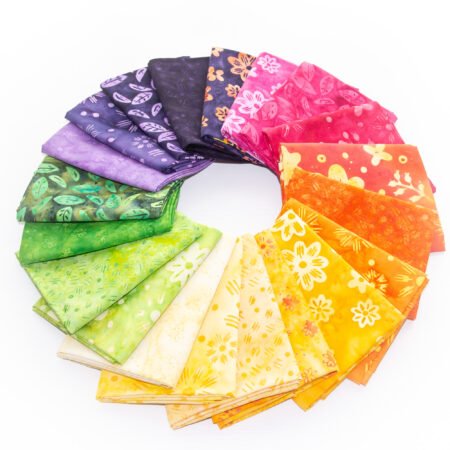 Top US quilting blog and shop, Kate Colleran Designs, shares about her 2026 temperature quilt and the braid blocks she will use! Image is a wheel of fabric in purples, yellow, oranges, greens and pinks.