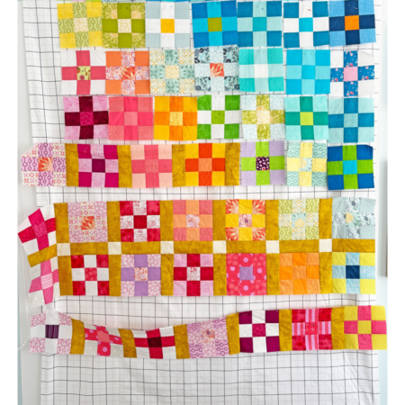 blocks for a nine patch quilt shown laid out on a design wall